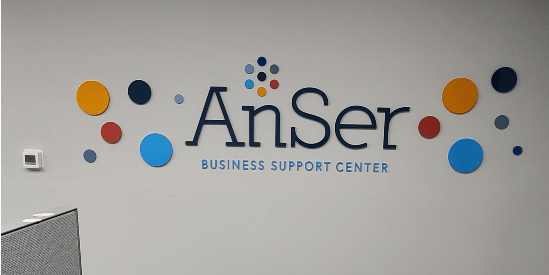 A sign on a wall that says anser business support center