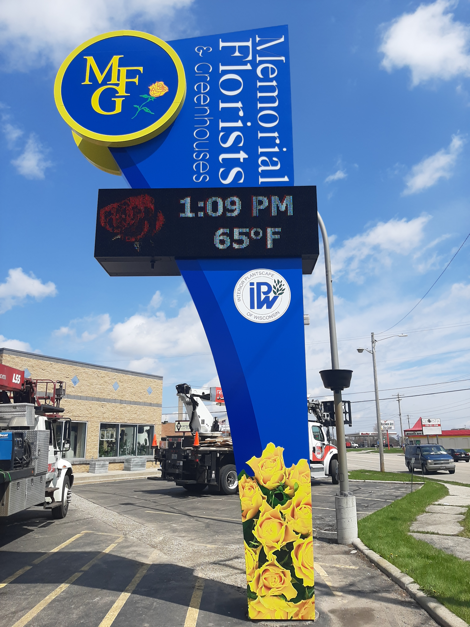 A sign for memorial florists shows the temperature is 65 degrees