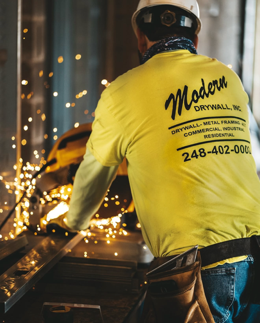 Man doing metal fabrication work with sparks flying.