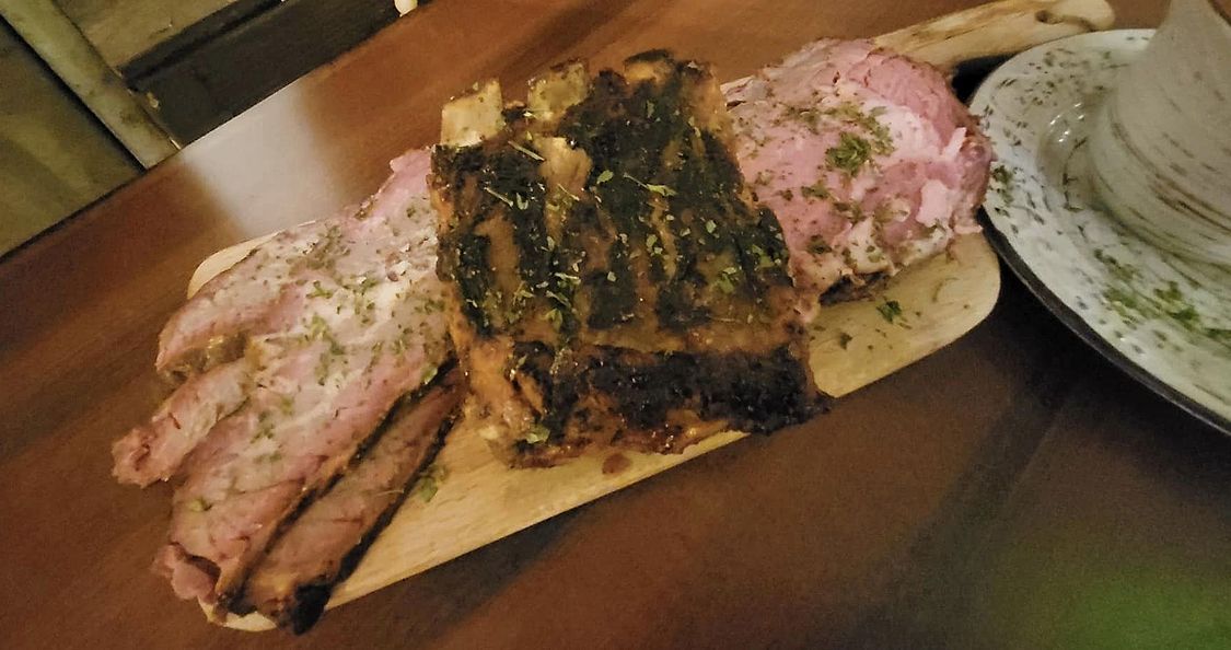 A wooden cutting board with meat and vegetables on it