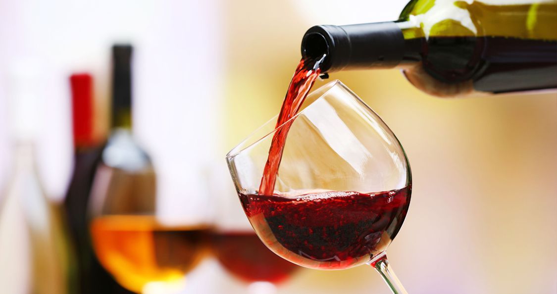 A bottle of wine is being poured into a glass