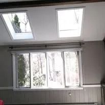 Interior room with two skylights and a large window letting in daylight