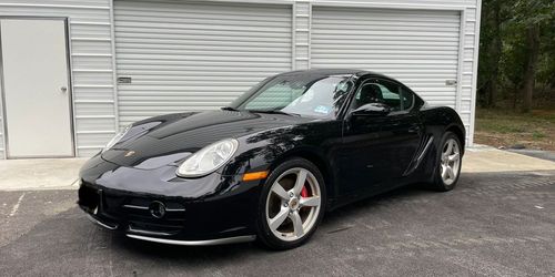 Black sports car parked in front of a white garage door