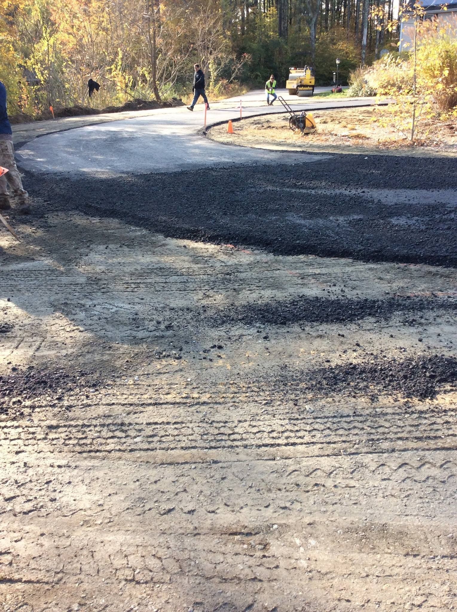 A group of people are walking down a dirt road.