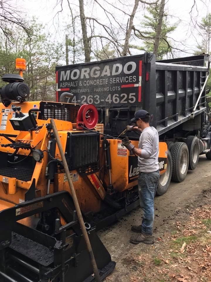 A man is standing next to a dump truck.