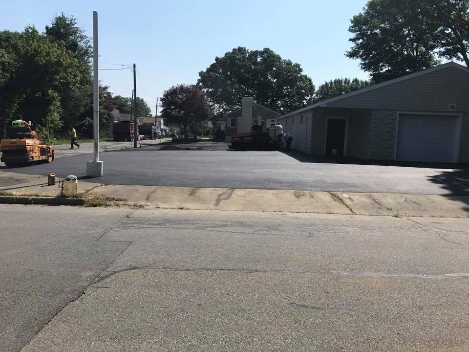 A driveway is being paved in front of a house