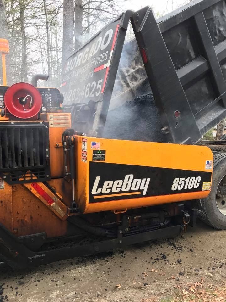 A yellow and black truck with the word leeboy on the side.