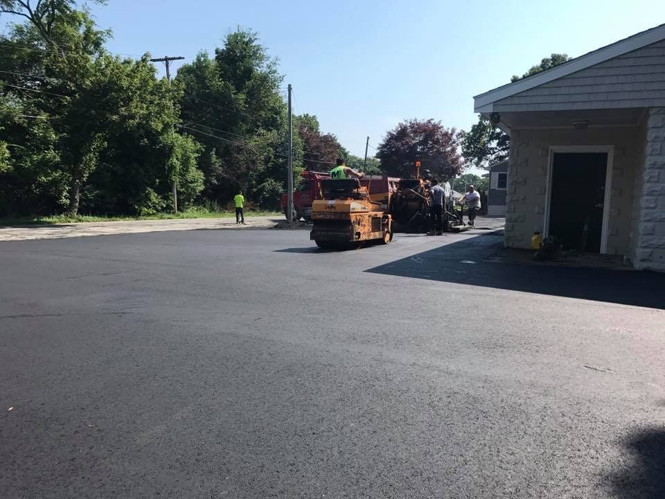 A truck is driving down a road next to a building