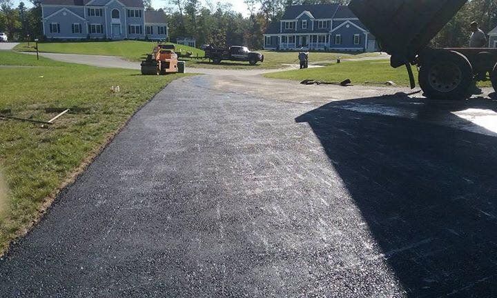 A driveway is being paved in front of a house