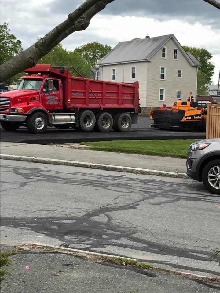 A red dump truck is parked on the side of the road