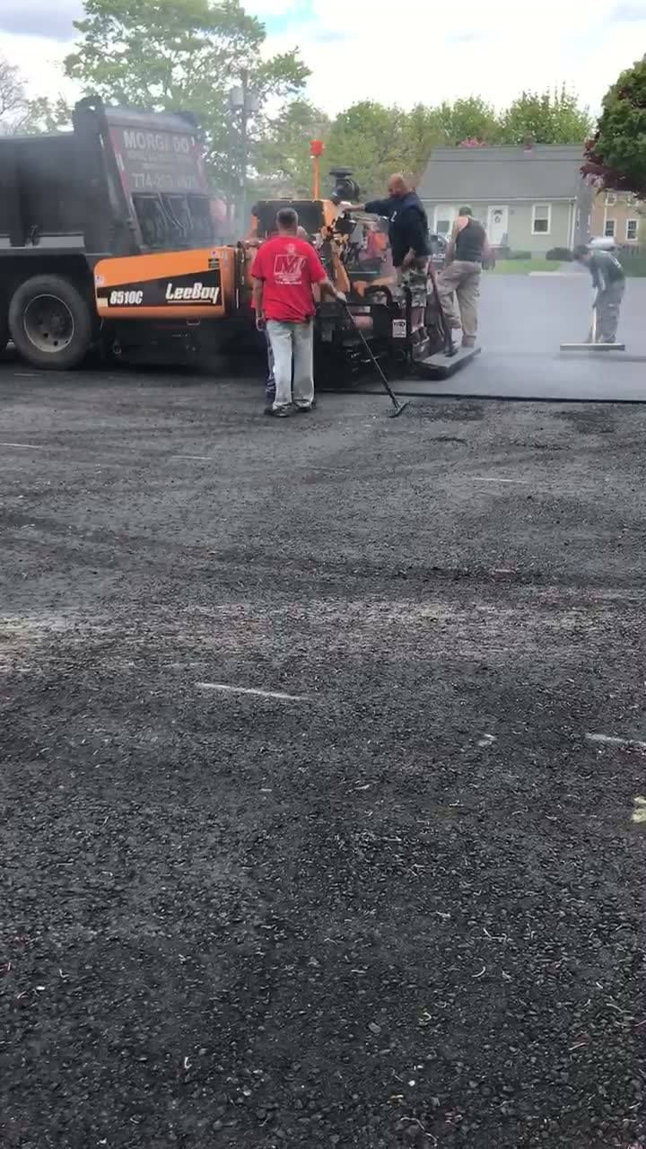 A group of people standing next to a truck in a parking lot.