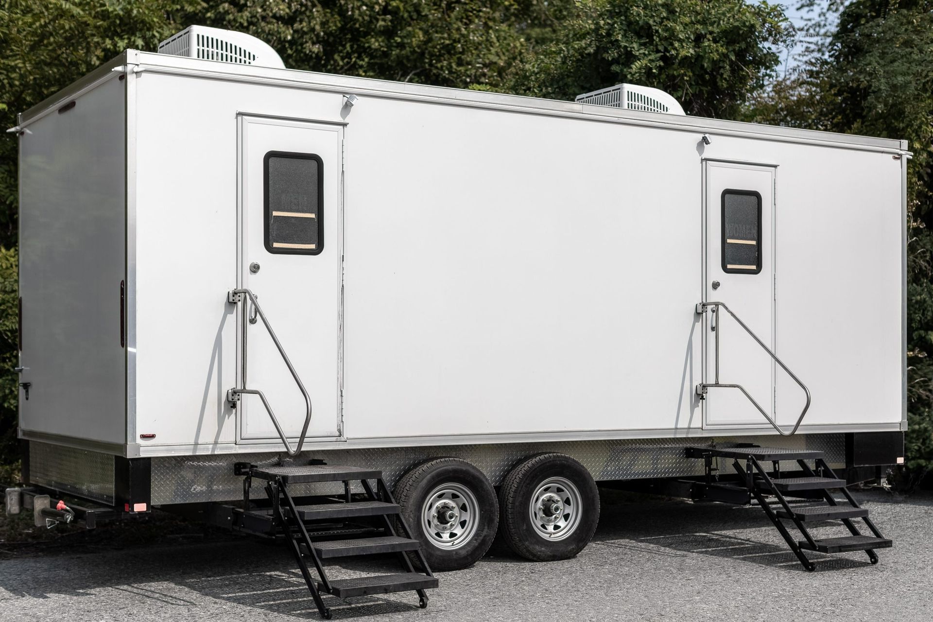 Portable restroom trailer with two separate entrances and staircases.