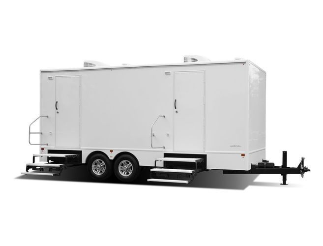 White, rectangular, portable restroom trailer with two doors, steps, and a trailer hitch.