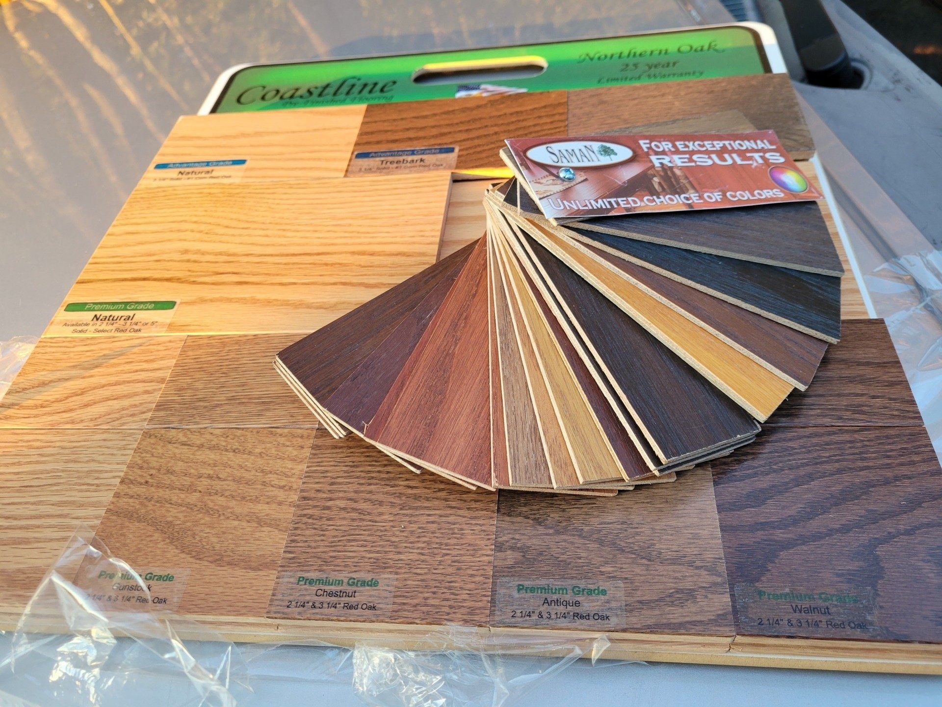 Wooden flooring samples and color swatches arranged on a wooden board.