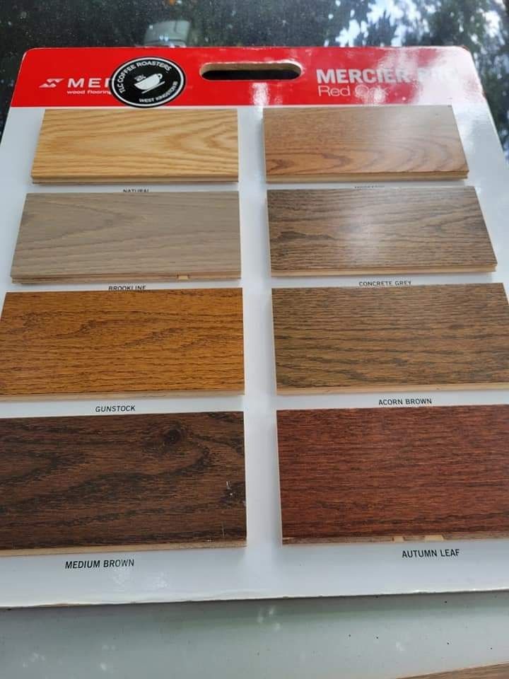 Wood flooring sample board with eight different stained planks, labeled 