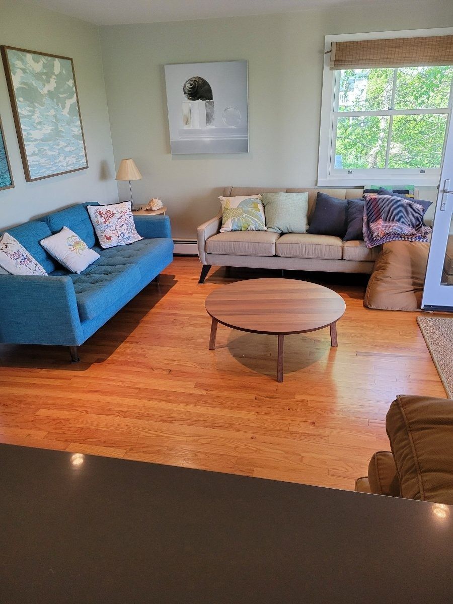 Living room with two couches, a round coffee table, and wood floors.
