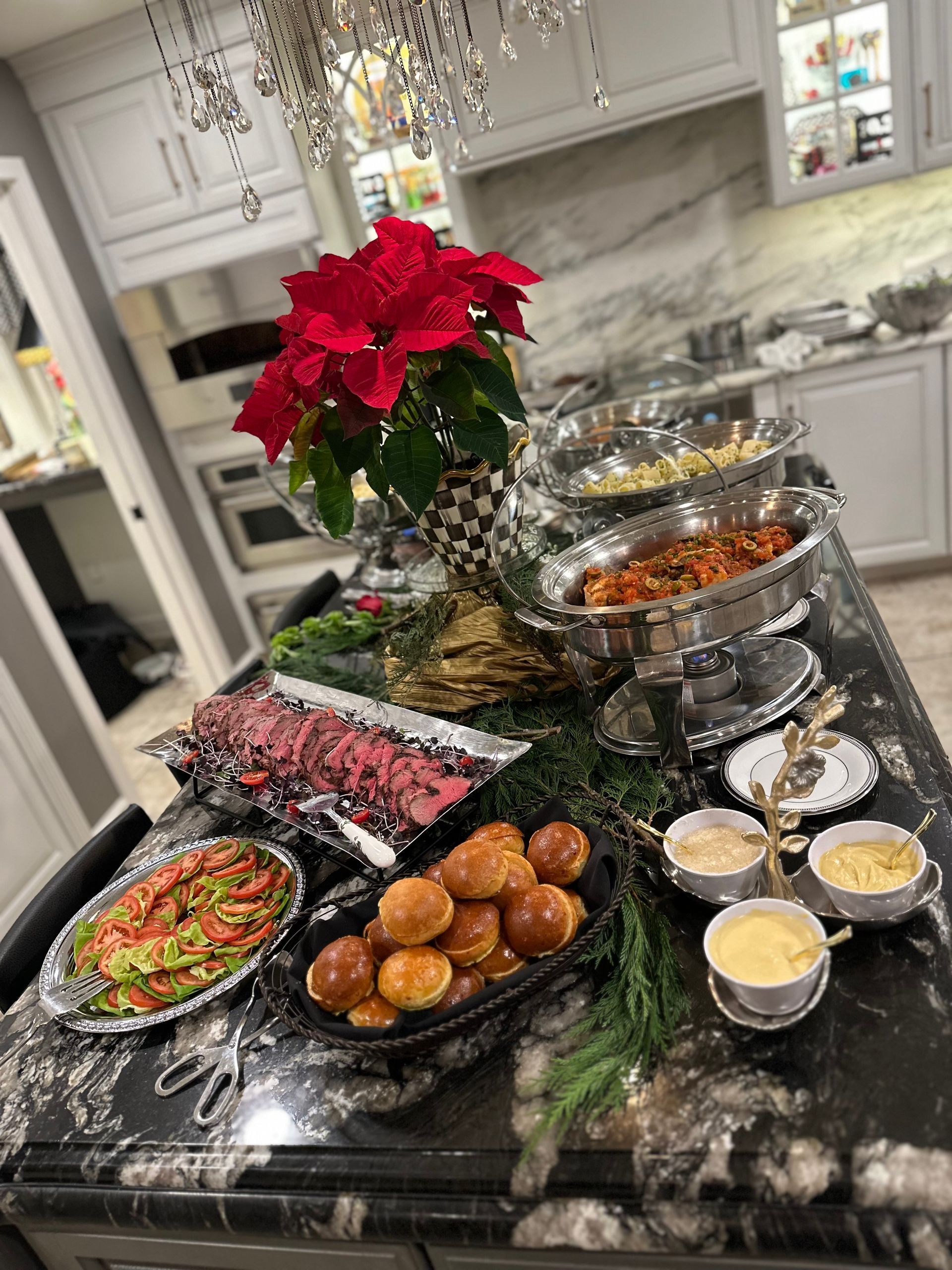 A kitchen counter filled with plates of food and a poinsettia.