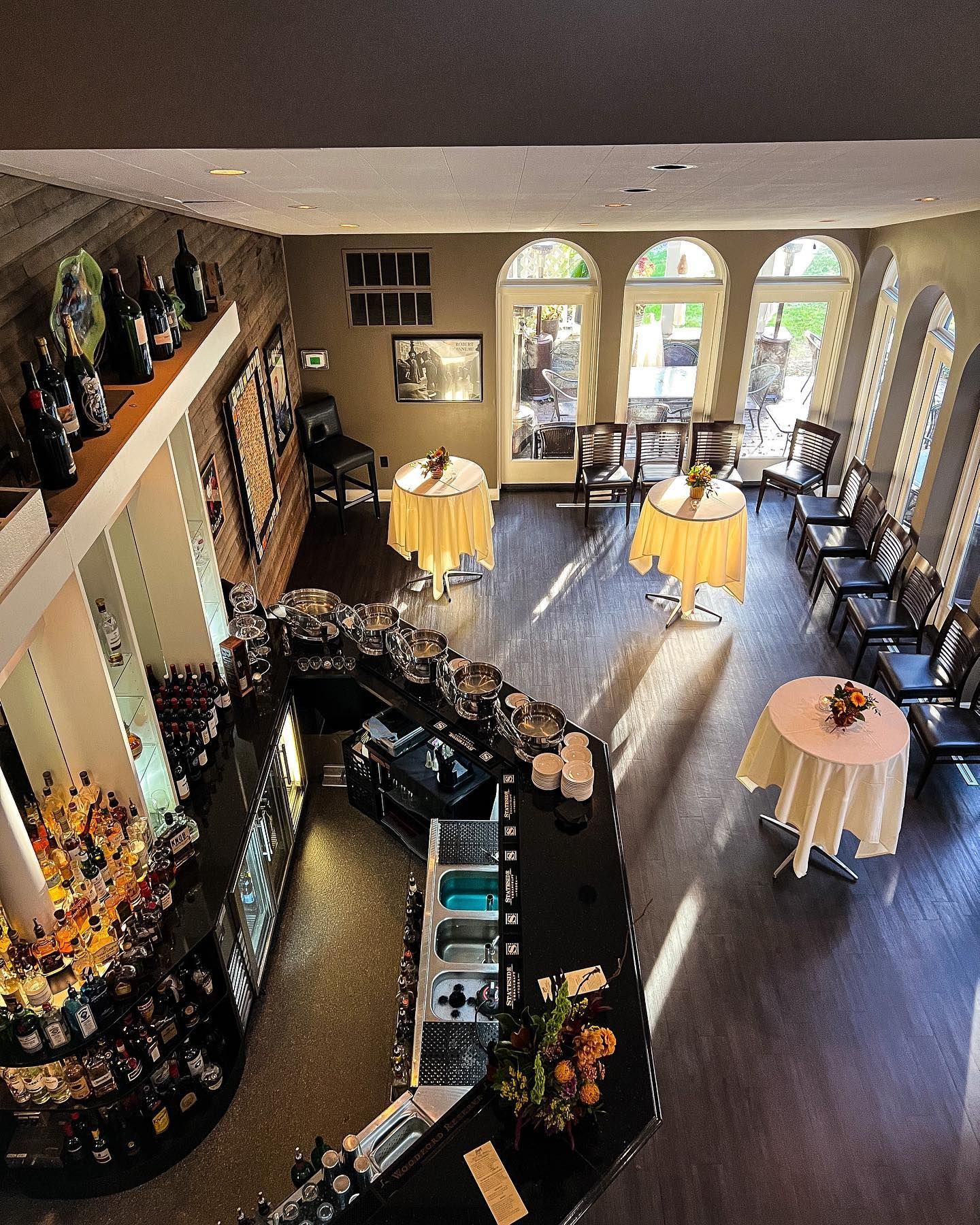 Elegant restaurant interior with arched windows, set tables, and a curved bar counter