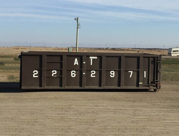 Dark brown dumpster labeled 