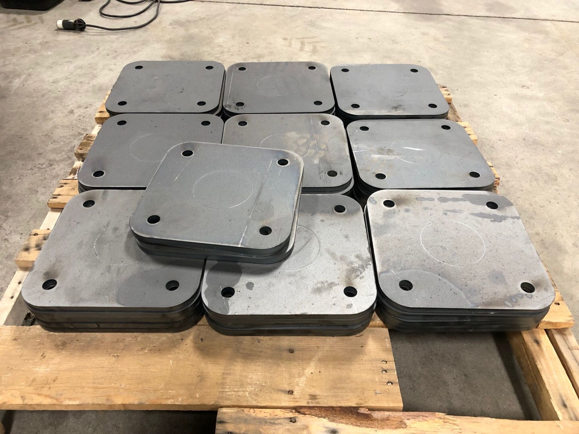 A wooden pallet filled with pieces of metal sitting on top of each other.