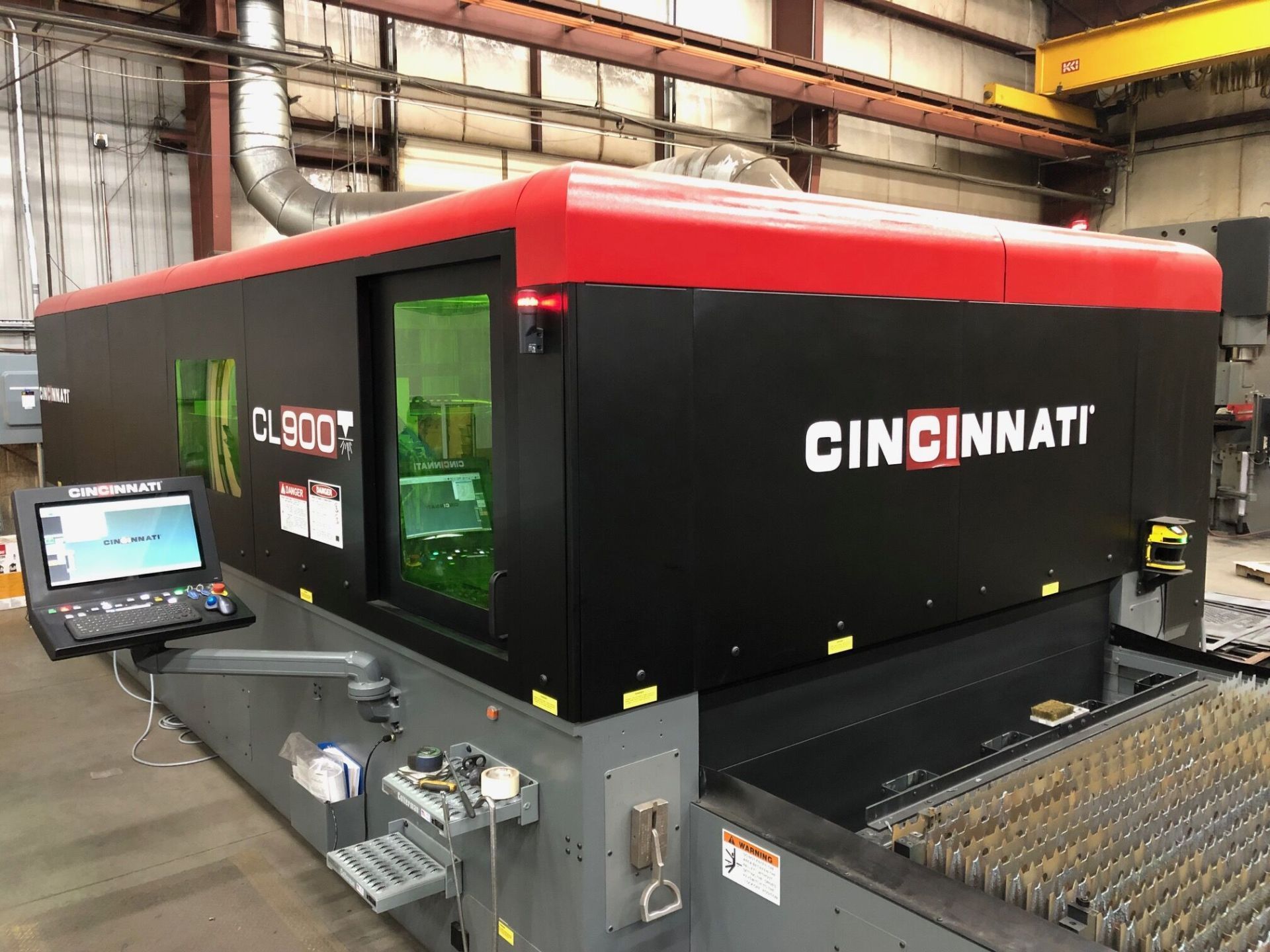 A cincinnati laser cutting machine is sitting in a factory.