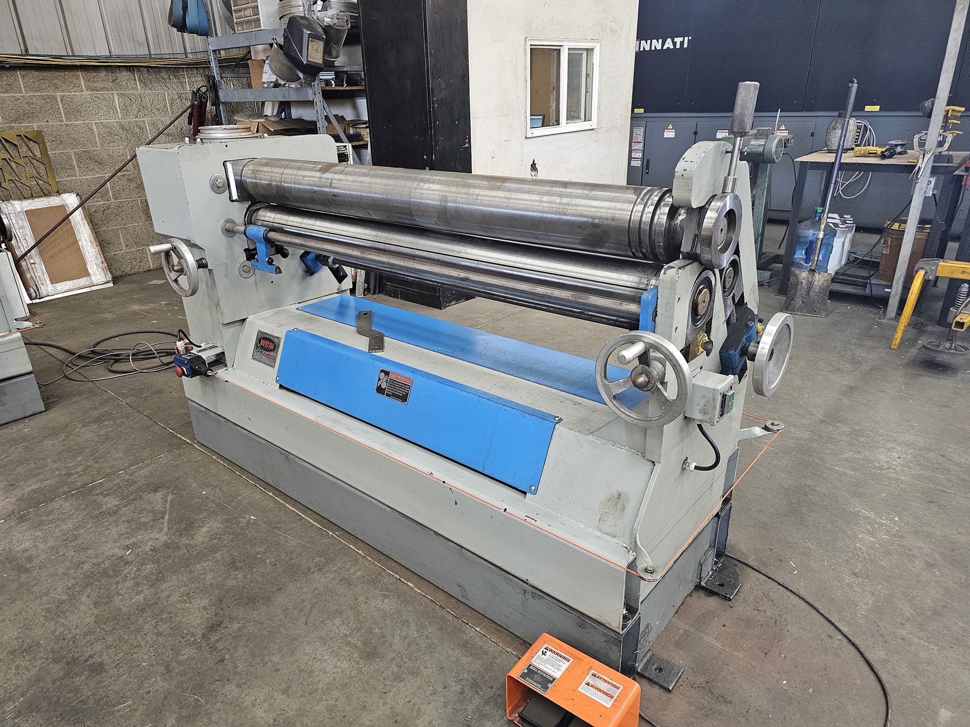 A machine is sitting in a warehouse next to a table.