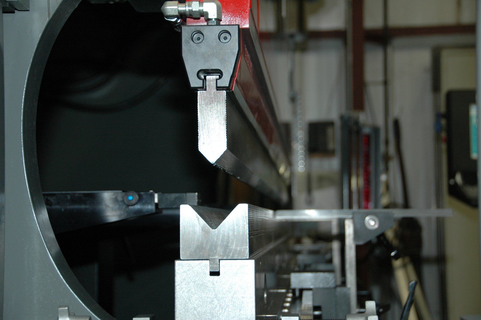 A machine that looks like a robot is cutting a piece of metal