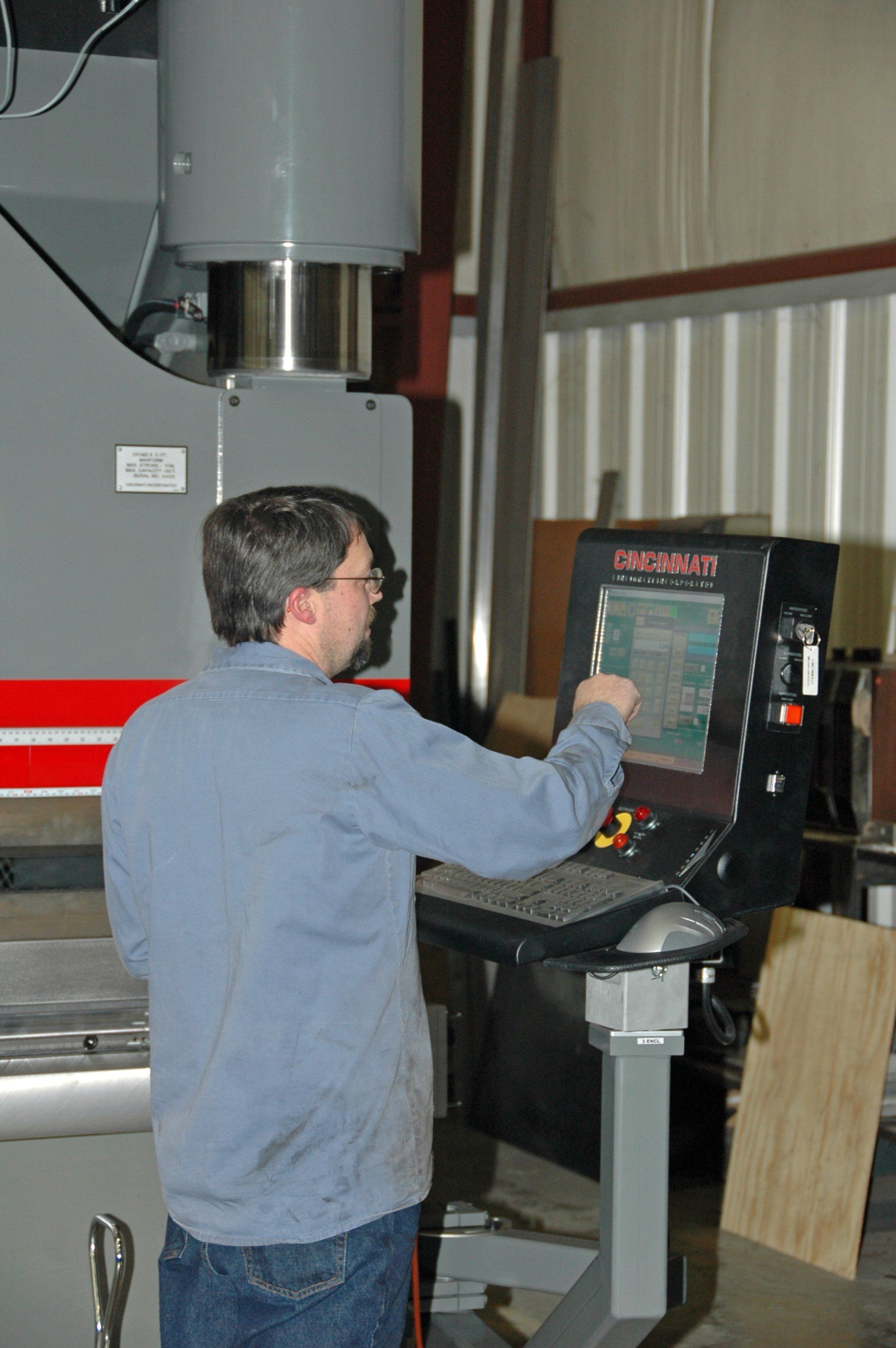 A man is standing in front of a machine that says necron on it.