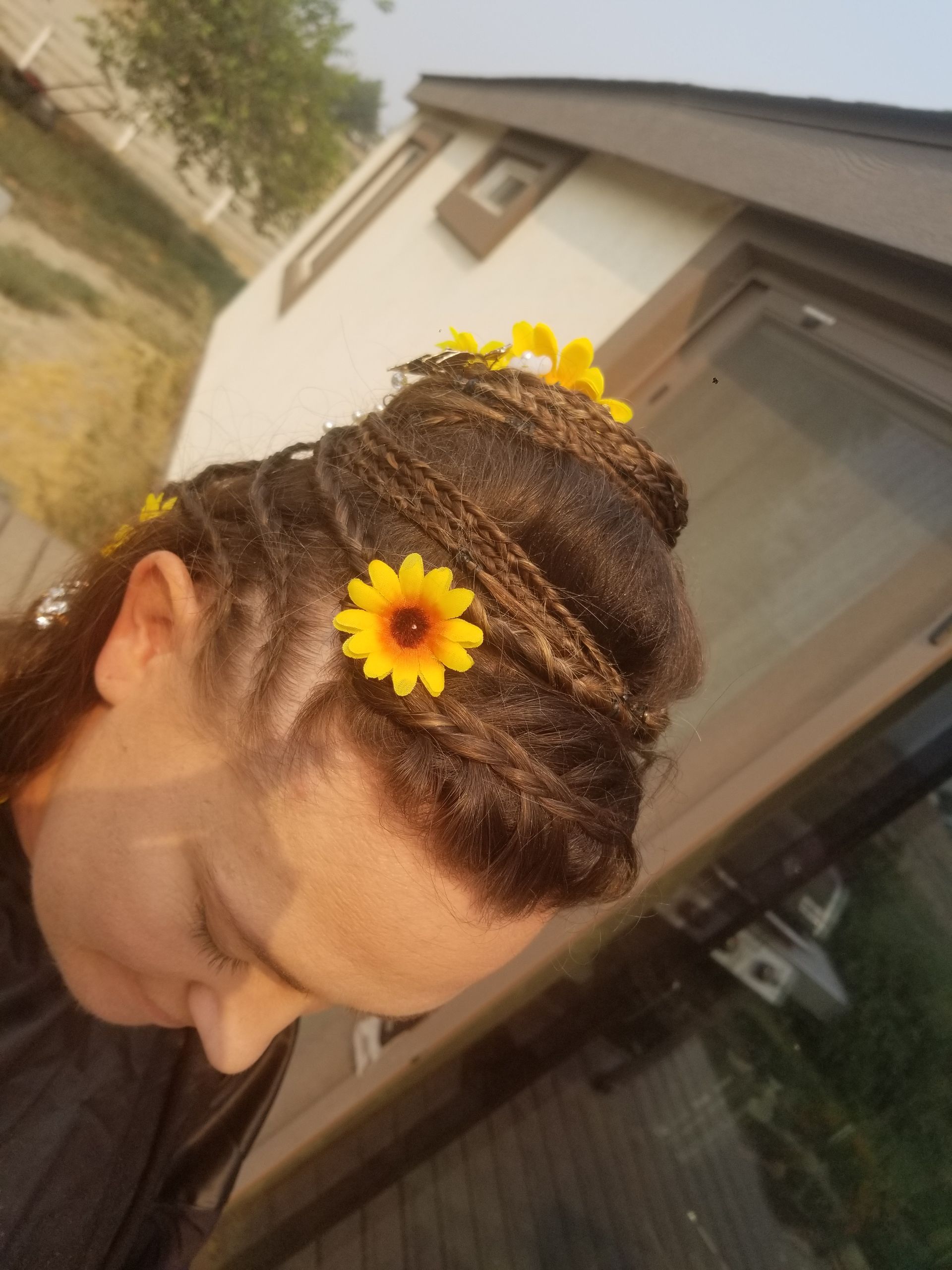 A woman with dreadlocks has a flower in her hair.