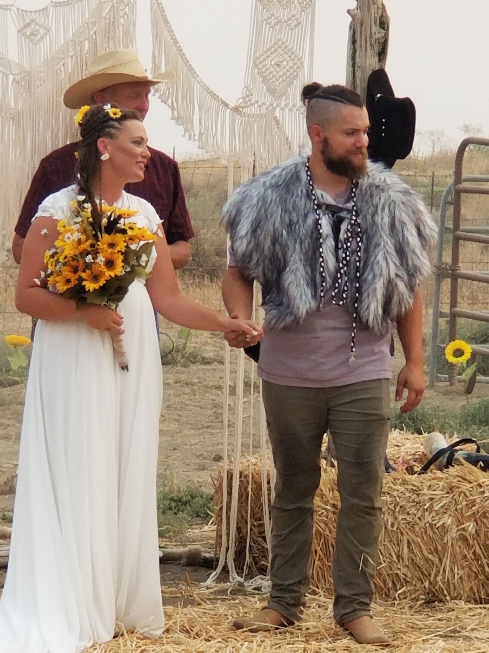 A bride and groom are holding hands during their wedding ceremony.