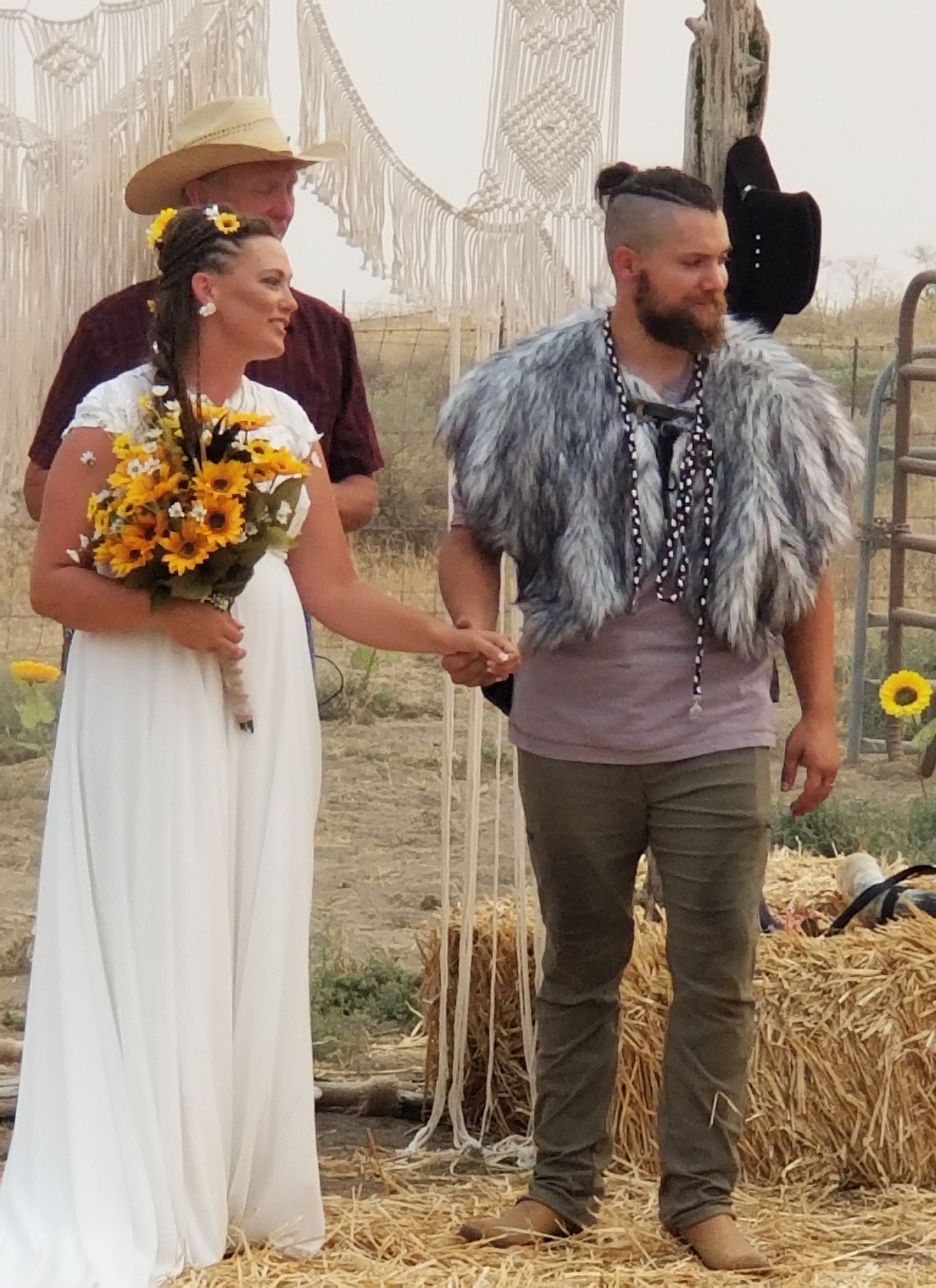 A bride and groom are holding hands during their wedding ceremony.