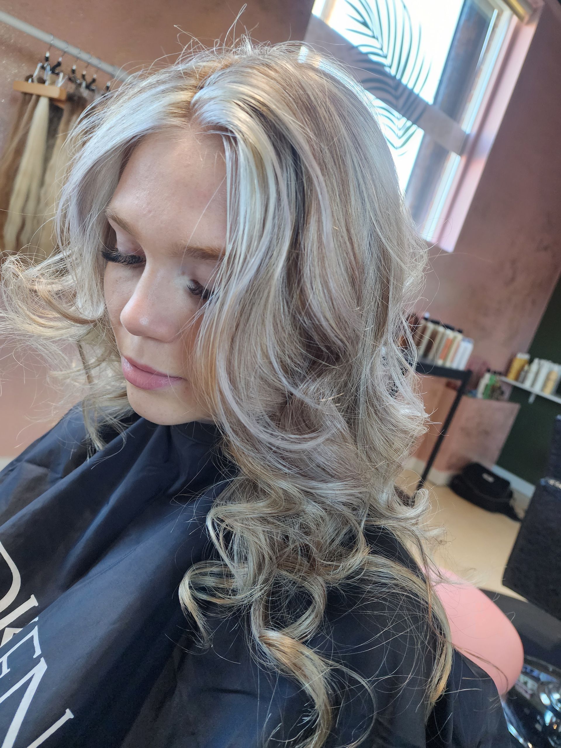 A woman is getting her hair cut at a salon.
