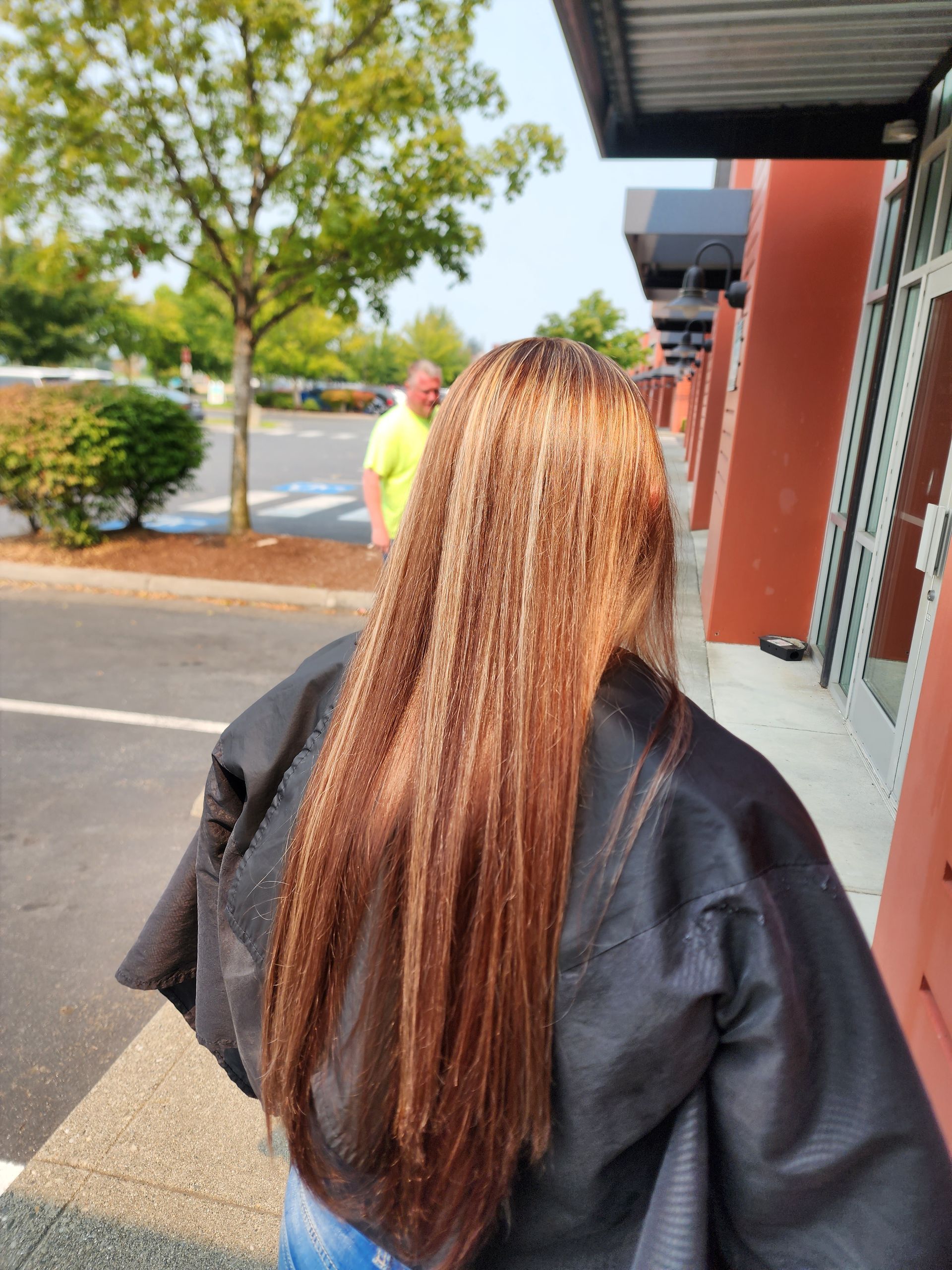 A woman with long brown hair is wearing a black cape.