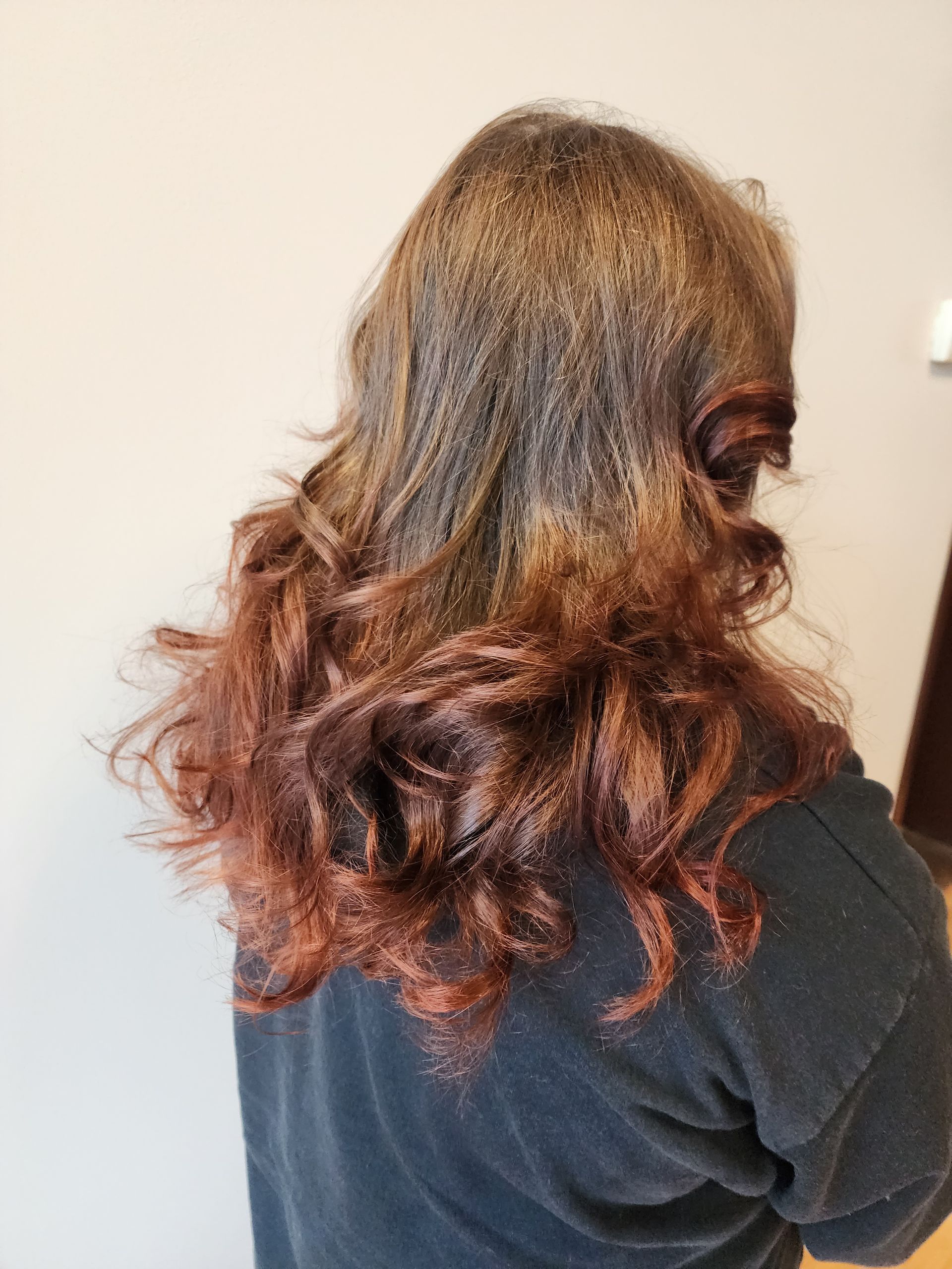 A woman with long brown hair is wearing a black sweater.