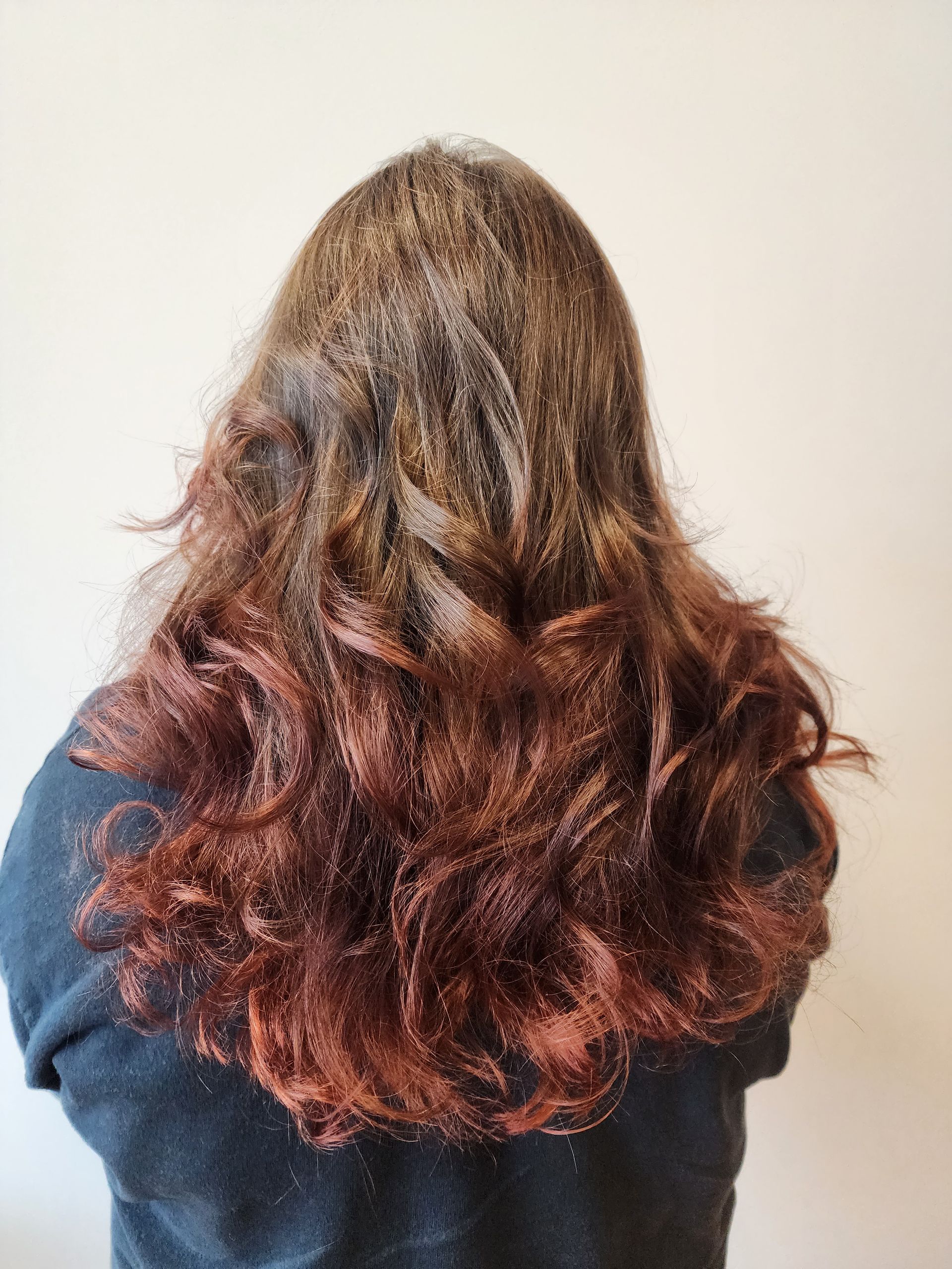 A woman with long brown hair is wearing a black sweater.