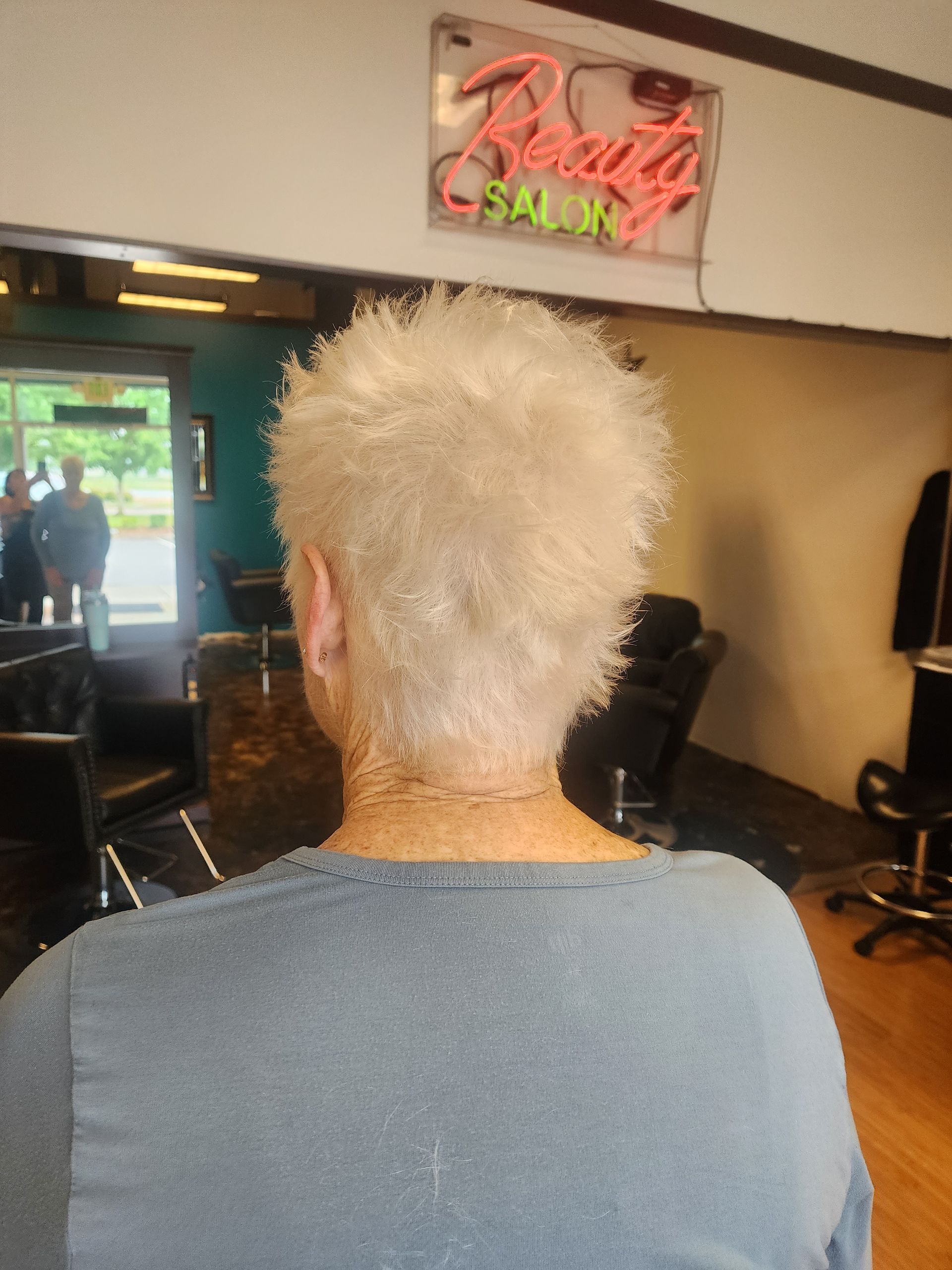 A woman is getting her hair cut in a beauty salon