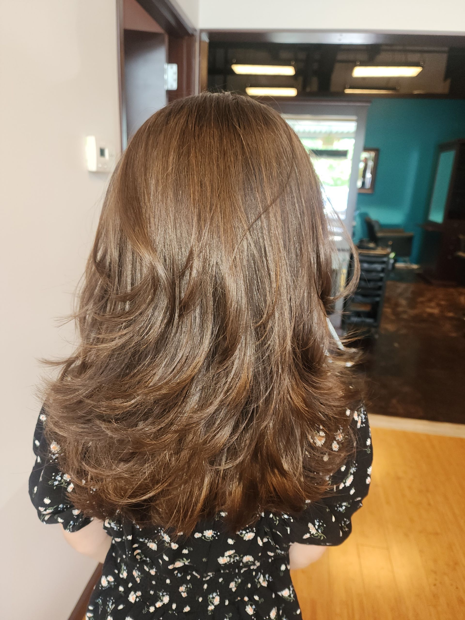 A woman with long brown hair is standing in a room