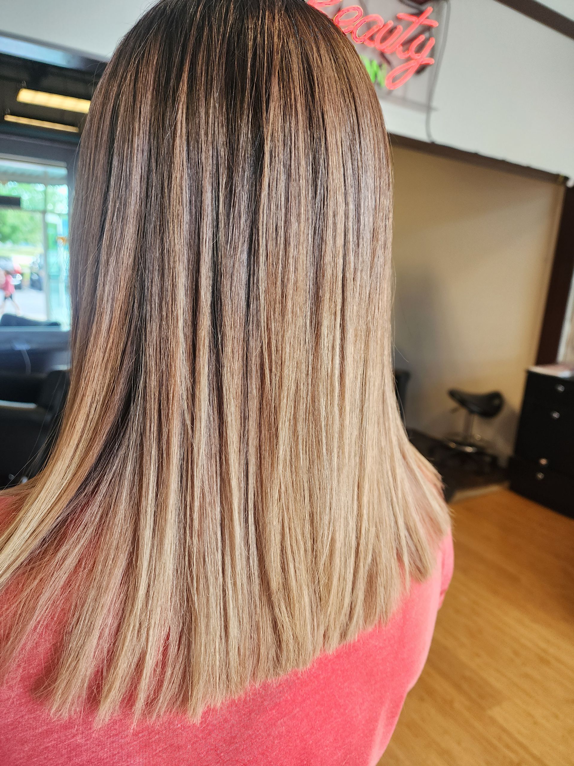 A woman with long hair is sitting in a chair in a salon.