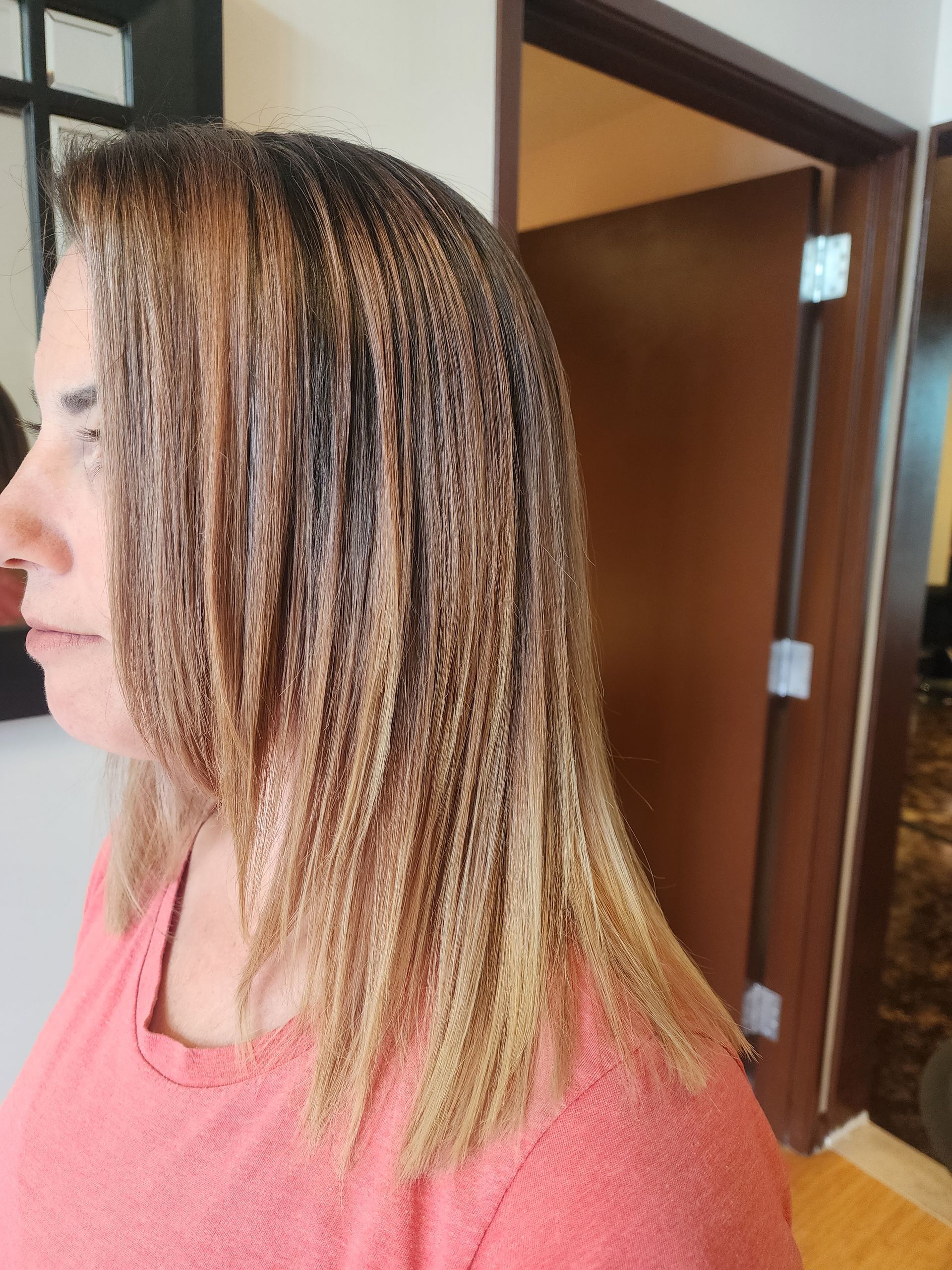 A woman with braided hair is wearing a pink shirt