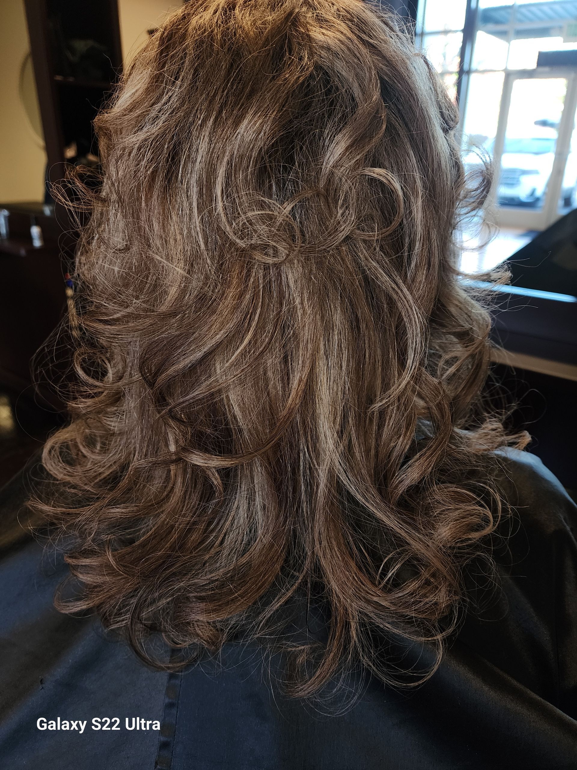 A woman is getting her hair dyed in a salon.