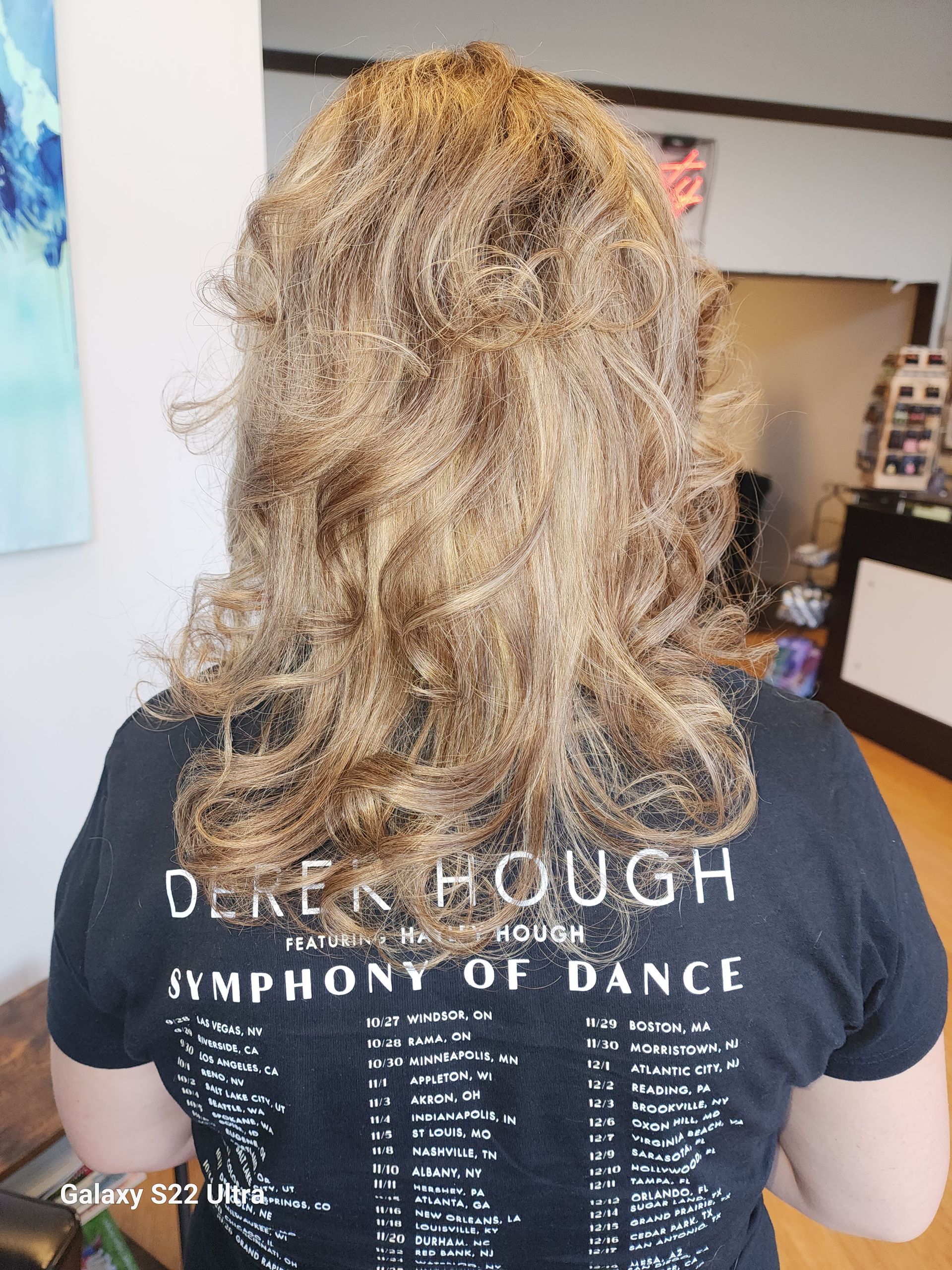 A woman is wearing a derek hough symphony of dance shirt