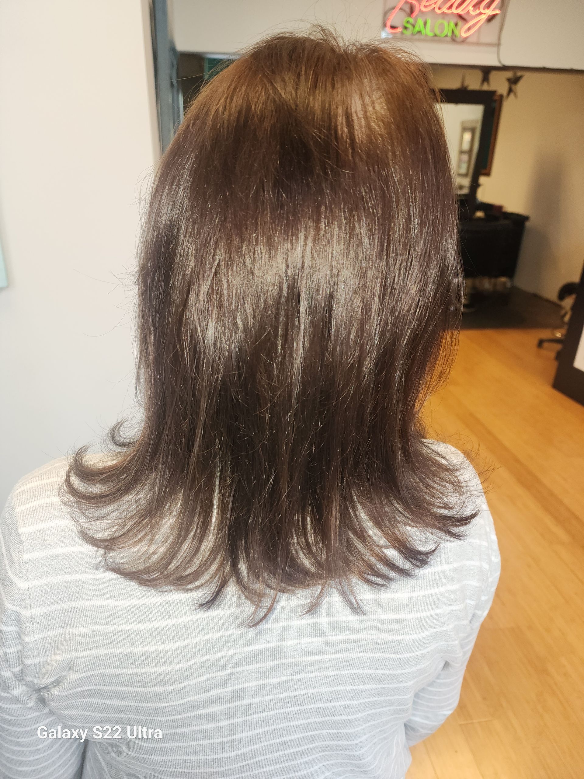 The back of a woman 's hair is shown in a salon.