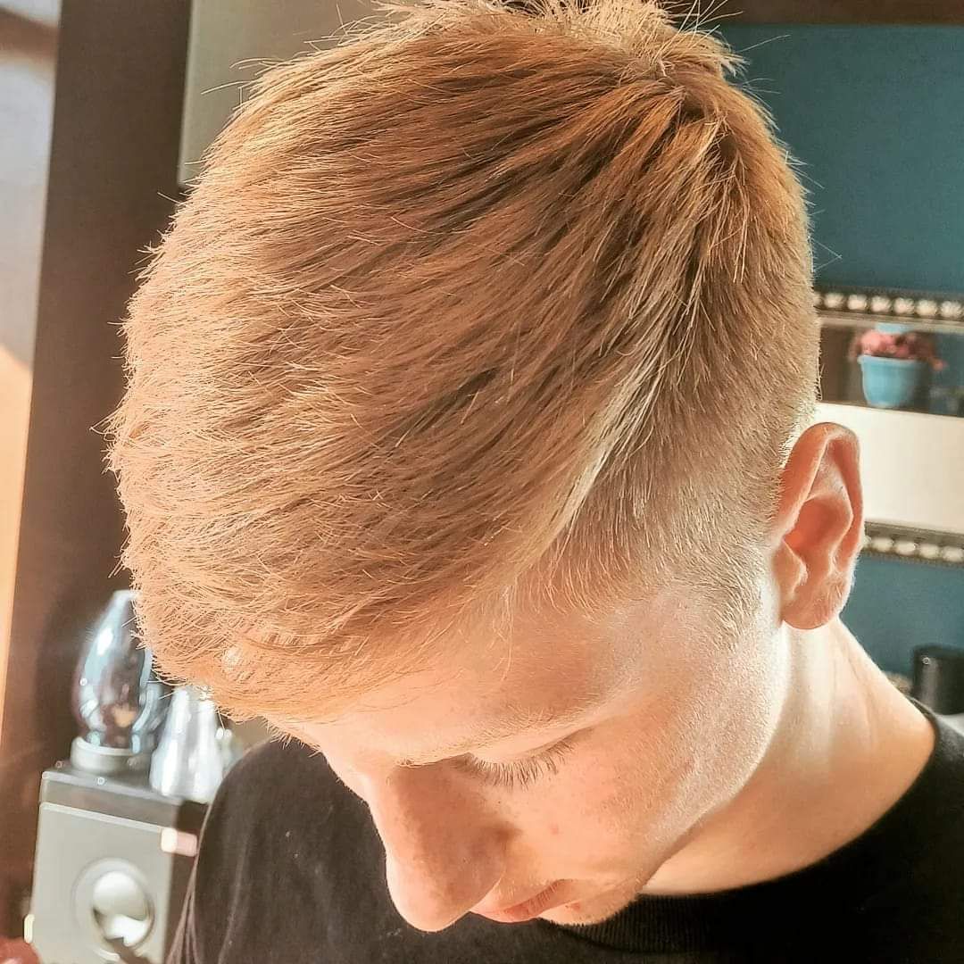 A young man with blonde hair is wearing a black shirt