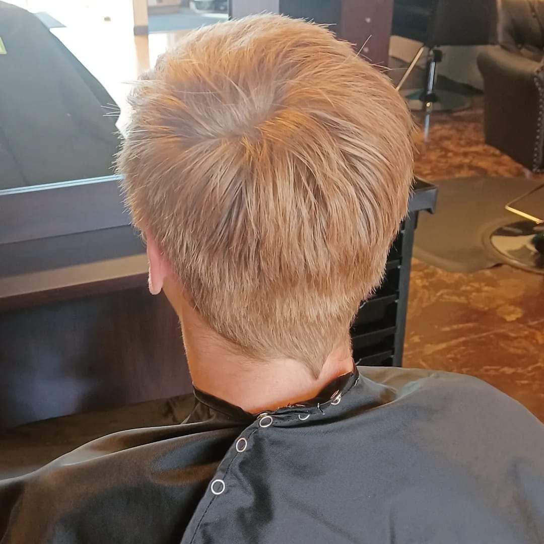 A man is getting his hair cut in a salon