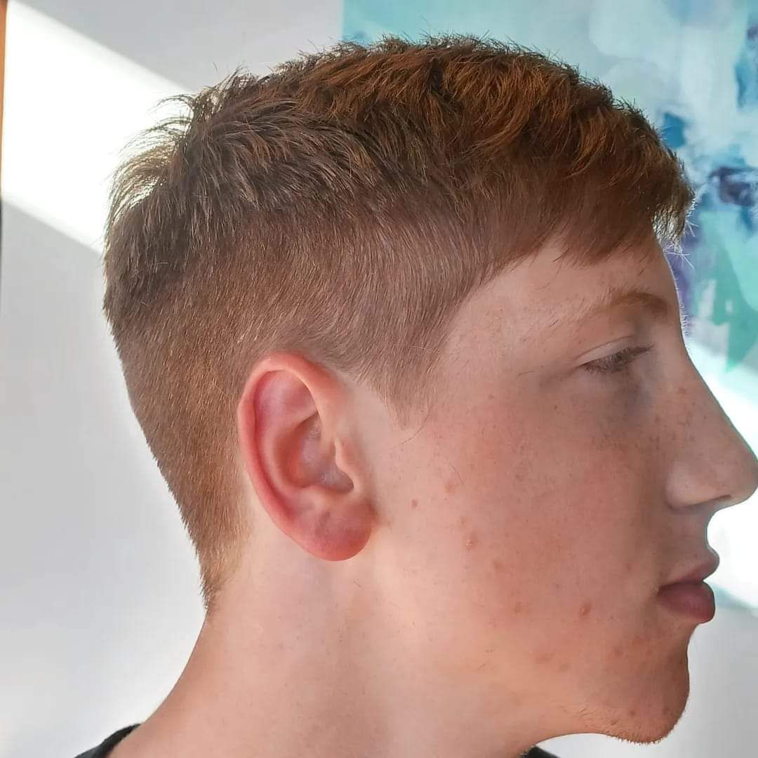 A close up of a young man 's face with a painting in the background