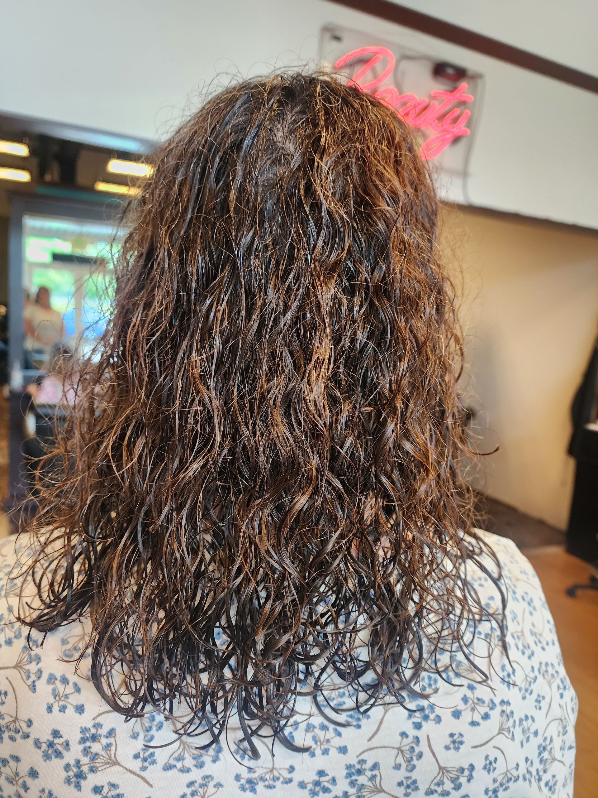 A woman with long curly hair is standing in a room.