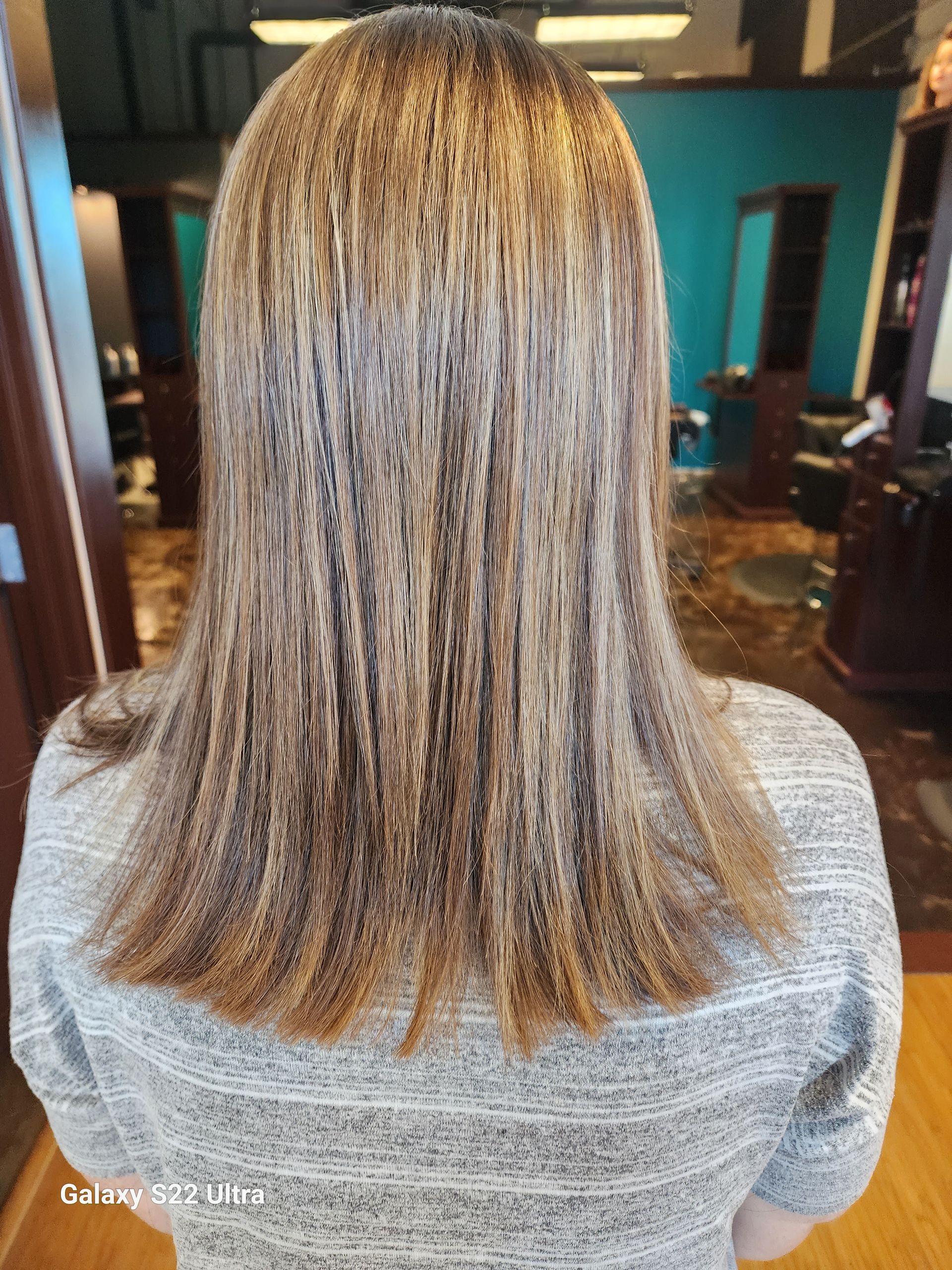 The back of a woman 's hair is shown in a salon.