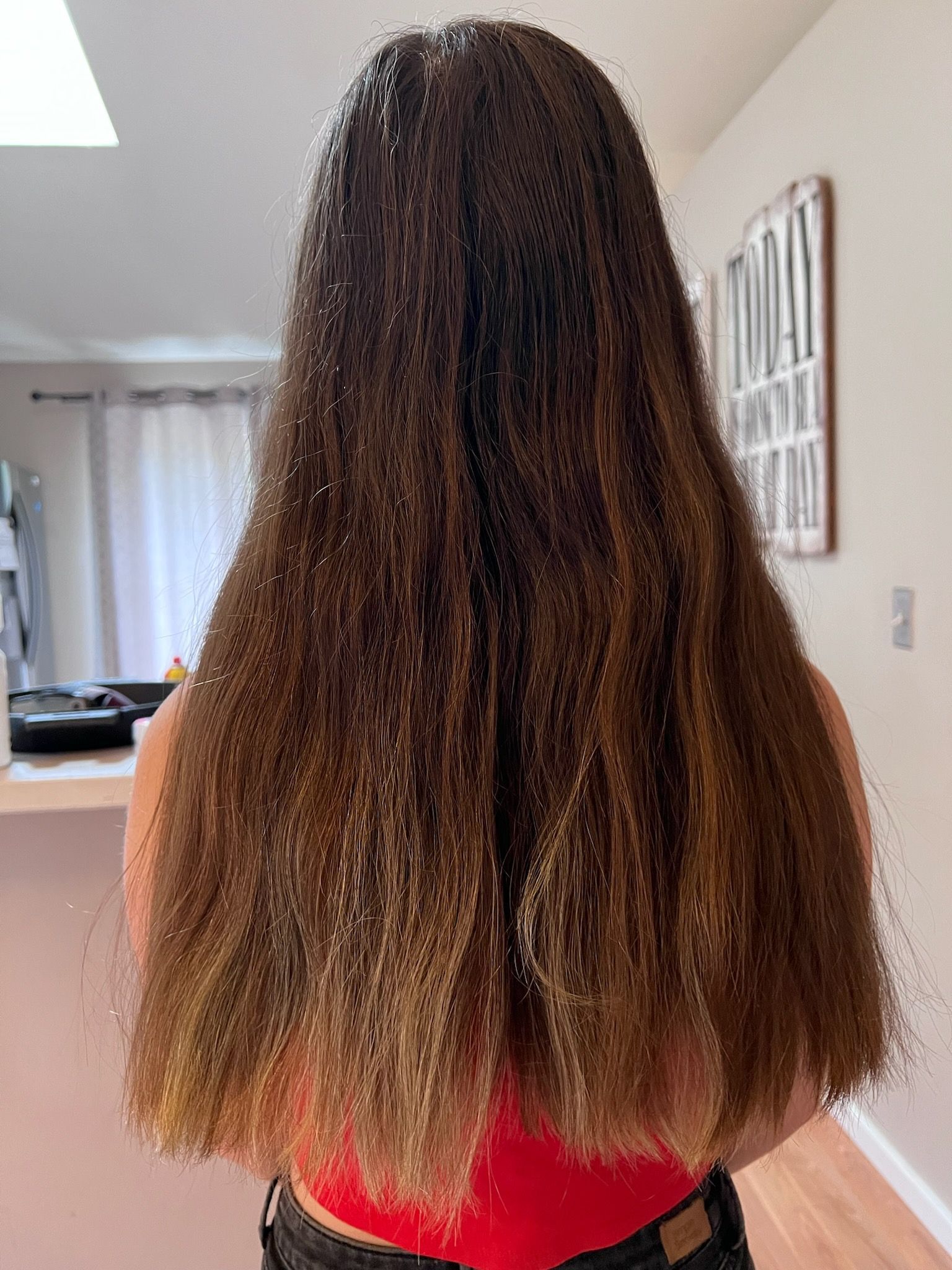 A woman with long hair is standing in a living room.