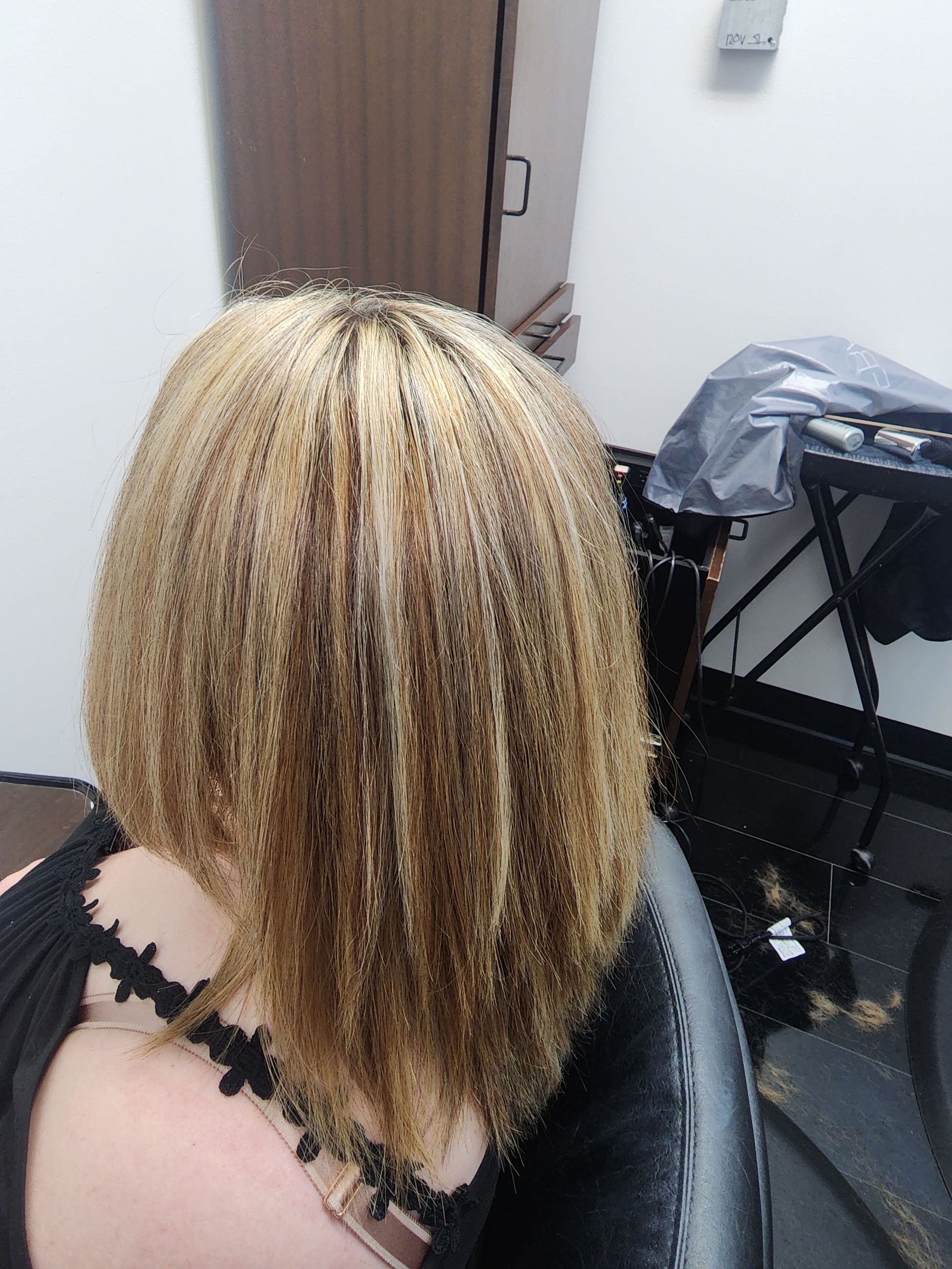 A woman with blonde hair is sitting in a chair