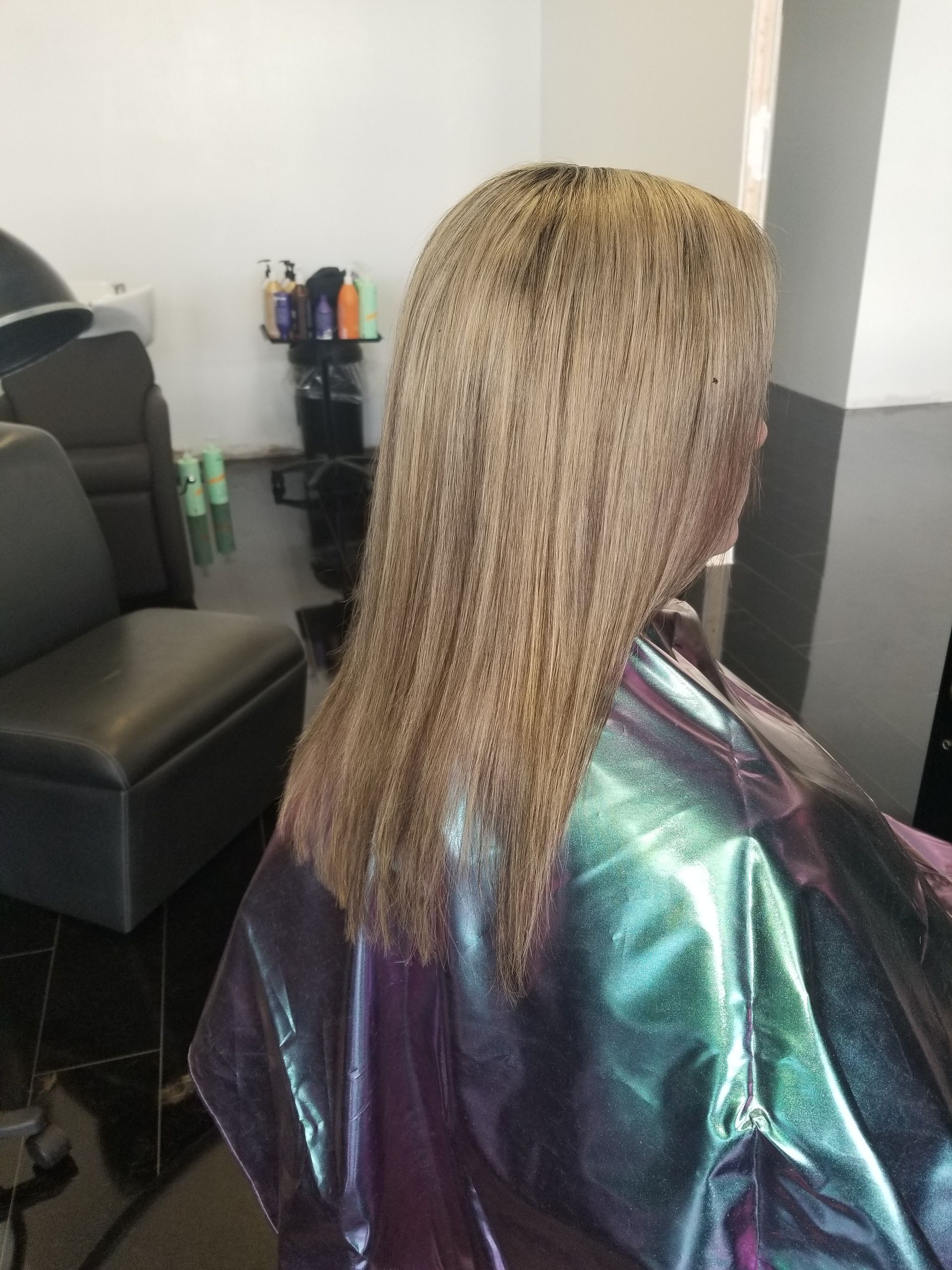 A woman is getting her hair cut in a salon